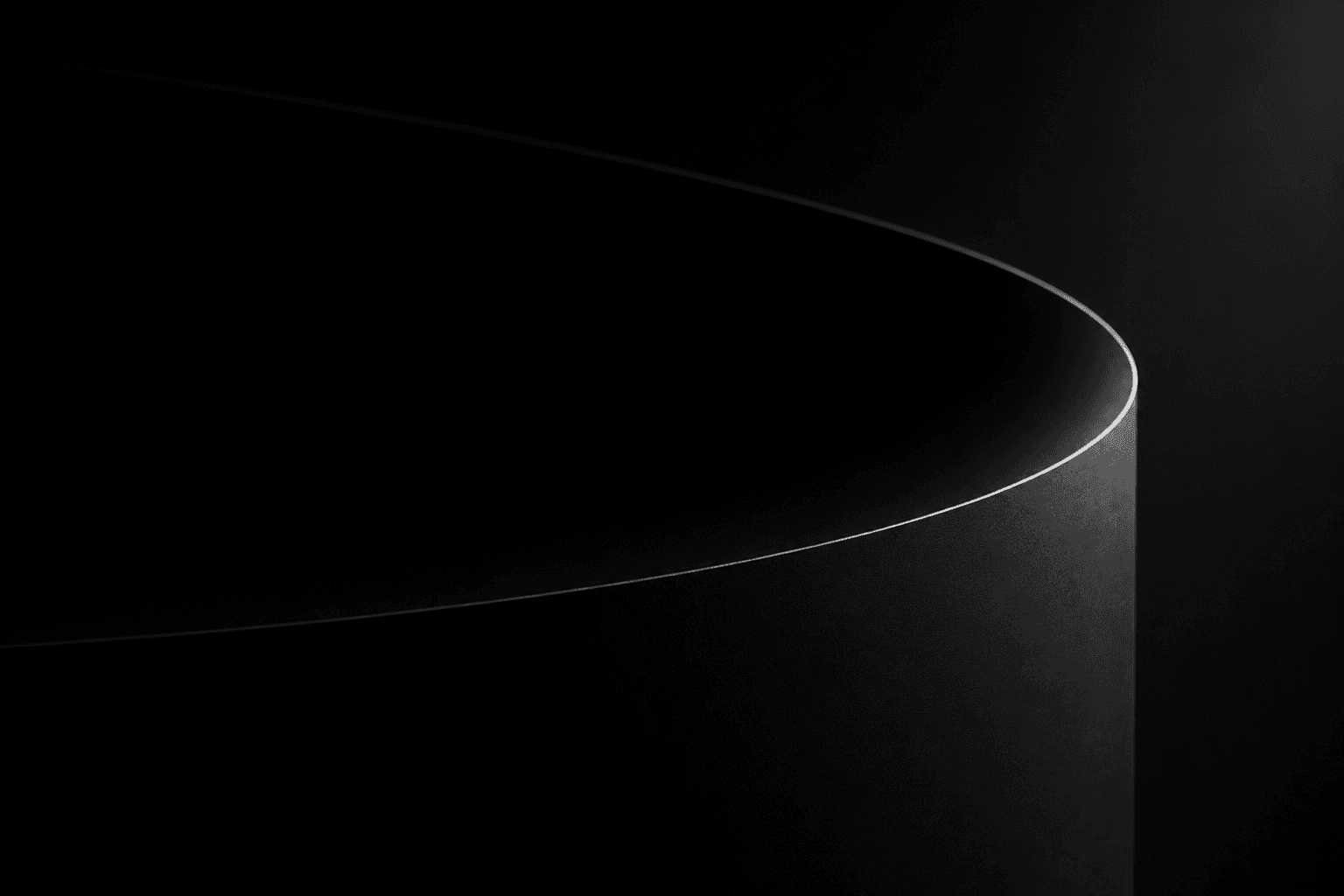 A matte black cylinder in near-darkness, a single bright line of light tracing its top edge